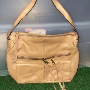 Beautiful cream leather purse with zipper and front pocket accents.